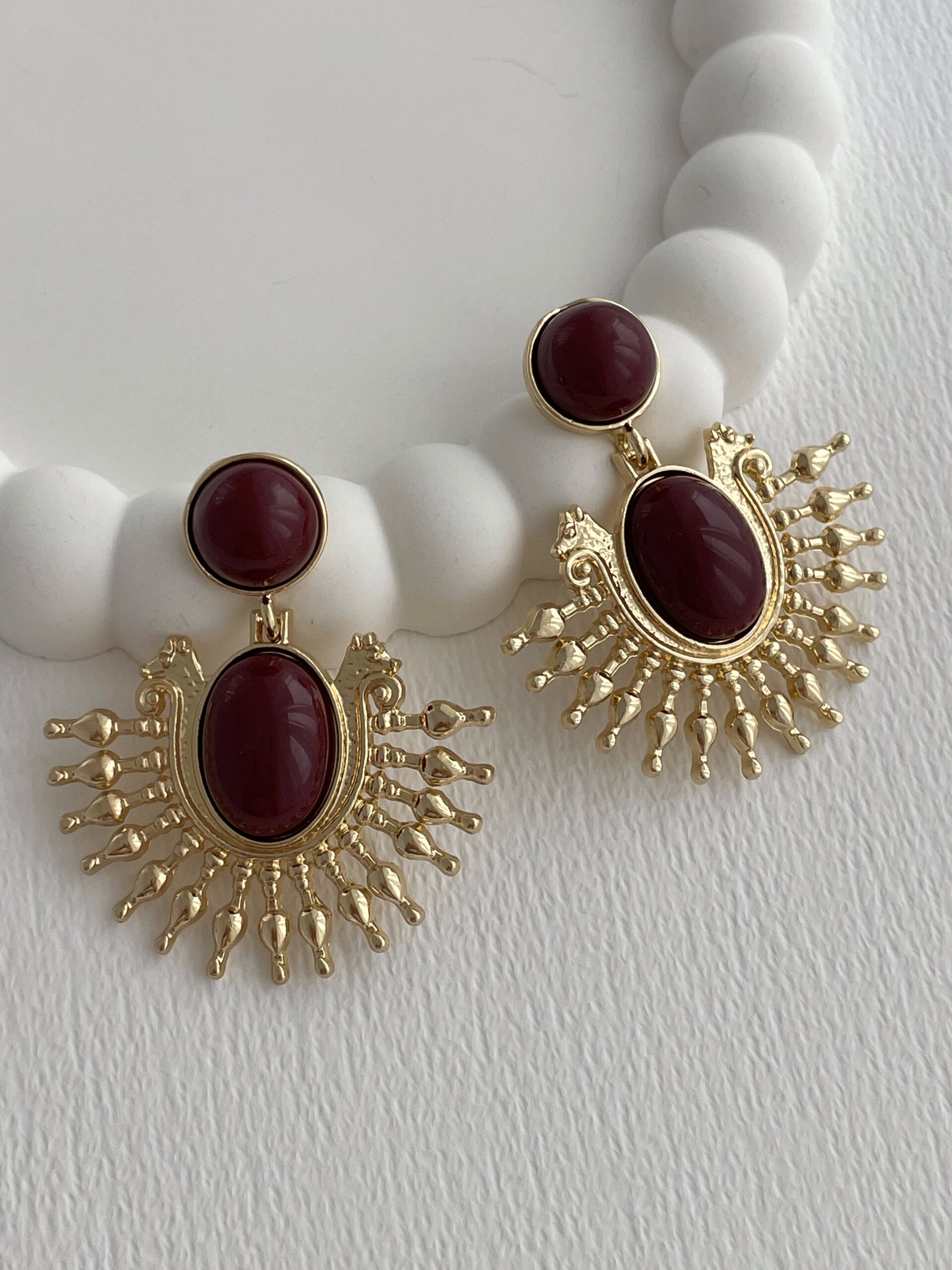 1770385666_0_6985f102a56d3.jpg Özel Seri Sallantılı Bordo Mineli Güneş Tasarım Gold Küpe